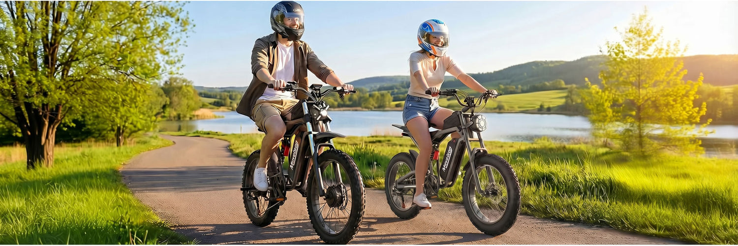 Two people riding electric bikes on a path near a lake with a scenic background. Moveloop eBike Official Store